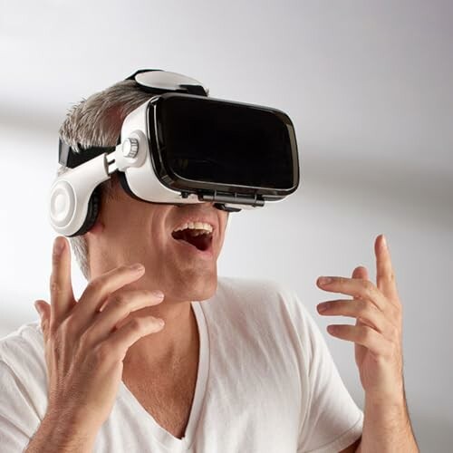 Man wearing a VR headset, appearing excited.
