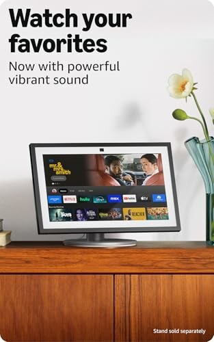 Smart TV displaying streaming services on a wooden table with flowers.