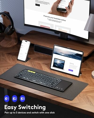 Wireless keyboard with easy switching feature, paired with phone and tablet on a desk setup.